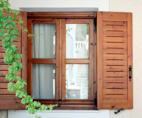 Fenêtre traditionnelle en bois clair sur mur rustique