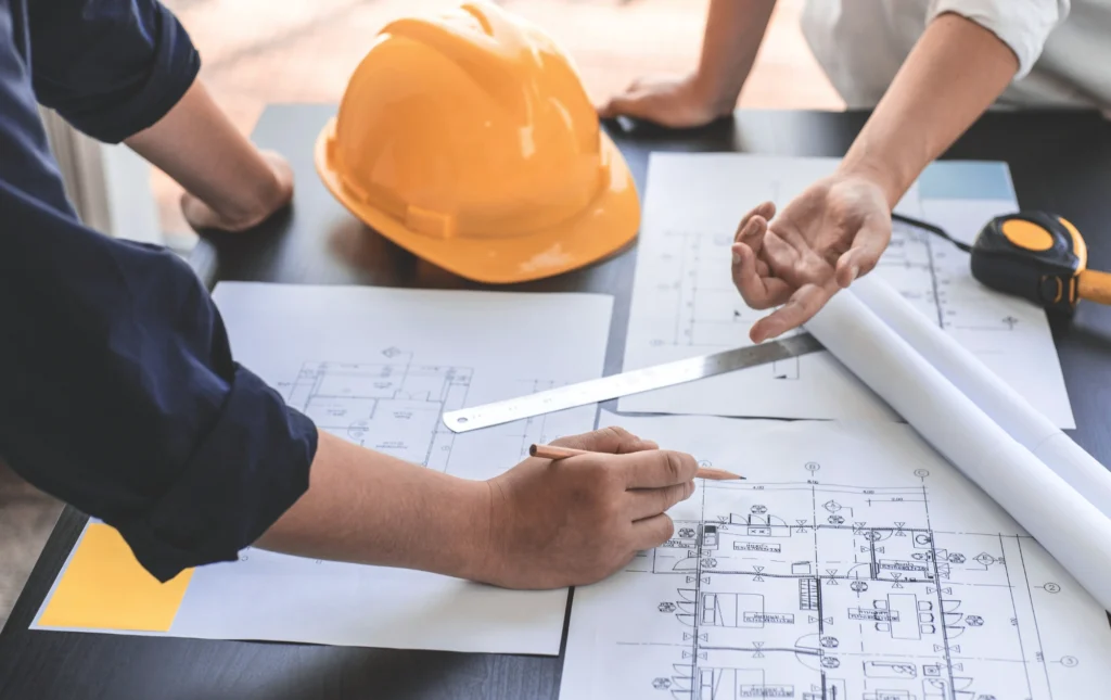 Réunion de conception entre architectes, ingénieurs et chef de chantier pour optimiser la structure.