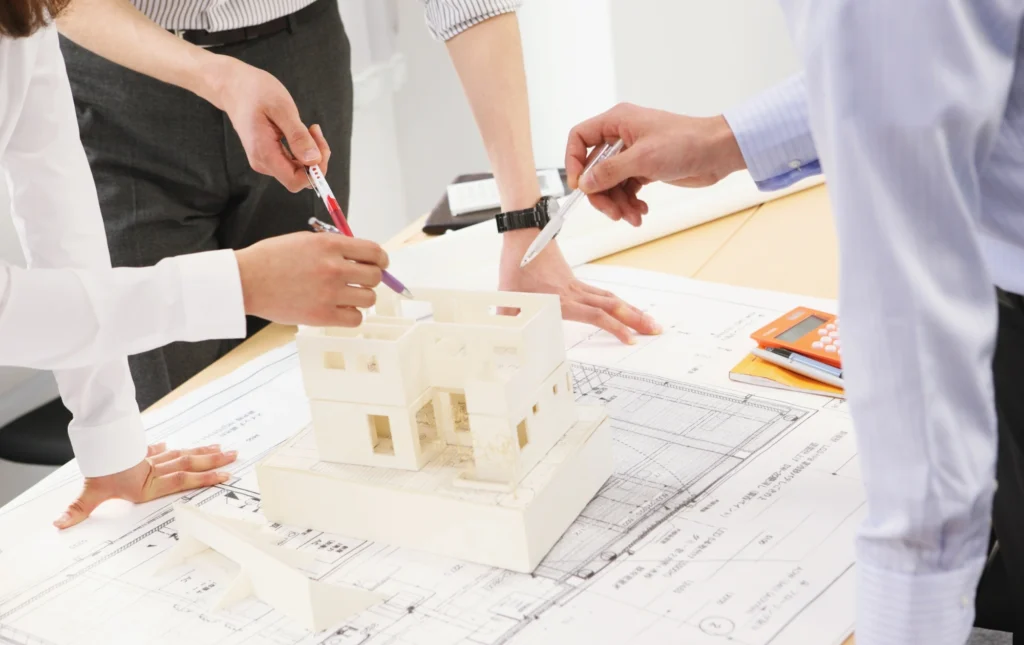 Équipe projet discutant autour de plans de construction.