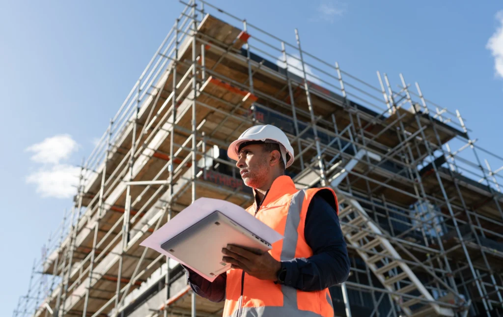 Suivi de chantier de construction avec ouvriers et plans techniques.